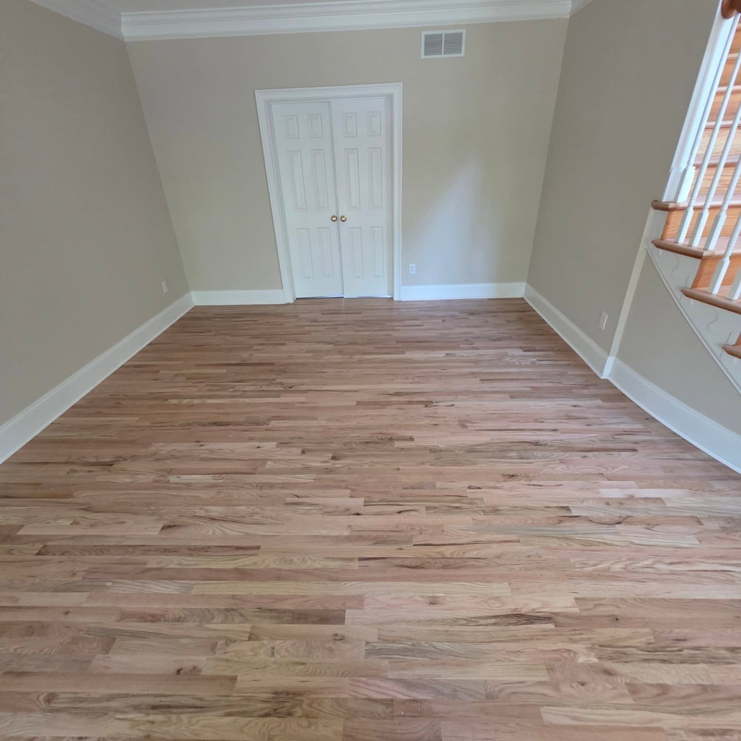 Newly installed hardwood plank flooring in an open room